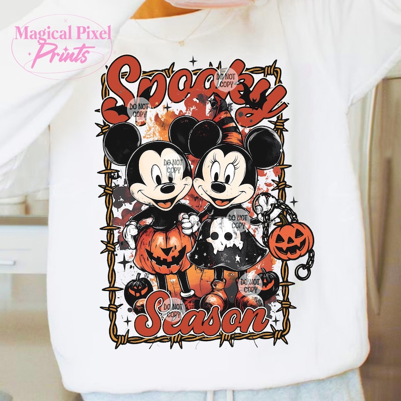 May include: White sweatshirt featuring Mickey and Minnie Mouse in Halloween costumes. The design includes the words "Spooky Season" and jack-o'-lanterns. The image is framed with a barbed wire design.