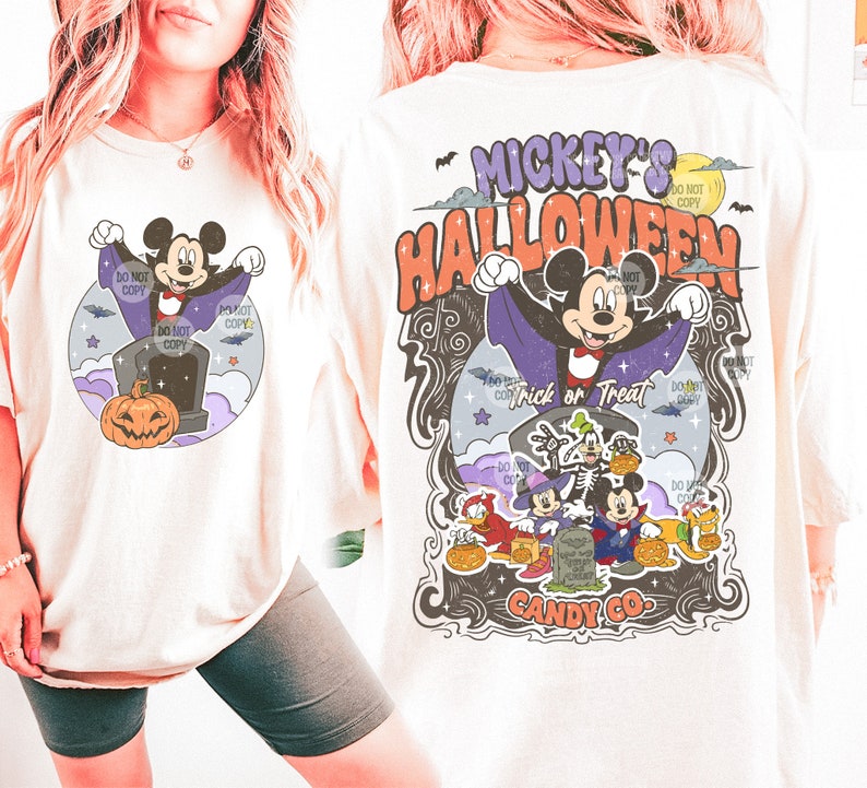Może przedstawiać: Kremowa koszulka z grafiką o tematyce Halloween. Projekt zawiera Myszka Miki przebranego za wampira, dynię oraz napis "Mickey's Halloween Trick or Treat". Tył koszulki ma podobny wz&oacute;r z innymi postaciami Disneya.