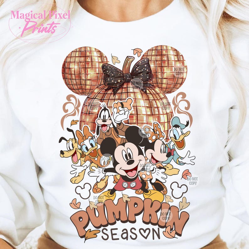 K&ouml;nnte beinhalten: Ein wei&szlig;er Pullover mit einem goldenen Glitzerk&uuml;rbis-Design und einer Gruppe von Disney-Charakteren, darunter Mickey Mouse, Goofy, Donald Duck und Pluto. Der Text "Pumpkin Season" steht unter den Figuren.