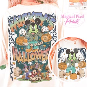 May include: A white t-shirt with a colorful graphic design featuring Mickey Mouse dressed in a green jacket and holding a pumpkin bucket. The text "Mickey's Not So Scary Halloween Party" is printed on the shirt.
