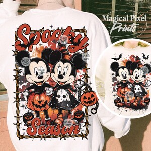 May include: White sweatshirt featuring Mickey and Minnie Mouse in Halloween costumes, holding jack-o'-lanterns. The design includes the words "Spooky Season" in a Halloween-themed font, with a barbed wire border.