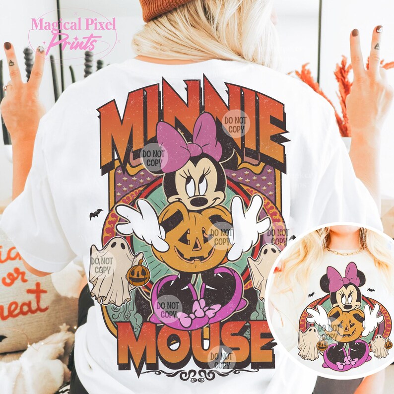May include: White t-shirt with a retro design of Minnie Mouse holding a jack-o'-lantern, with ghosts and the text "MINNIE MOUSE". The design has orange, purple, and pink accents, ideal for Halloween.