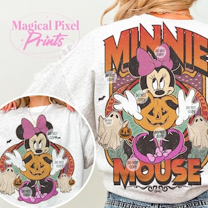 May include: A light grey sweatshirt with a Halloween-themed Minnie Mouse design. The graphic features Minnie Mouse, a jack-o'-lantern, ghosts, and the text "MINNIE MOUSE". The design has a vintage, distressed look with the text "Magical Pixel Prints".