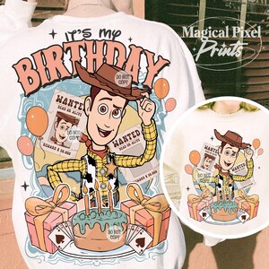 May include: A white t-shirt with a cartoon image of Woody from Toy Story. The image includes a birthday cake, presents, and balloons. The text "It's my Birthday" is written in pink letters on the shirt.