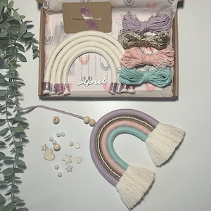 May include: A rainbow macrame kit with pastel coloured yarn, wooden beads, and wooden stars and hearts. The kit includes instructions and all the materials needed to create a rainbow wall hanging.