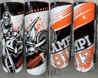 May include: Three black and white tumblers with orange accents. The tumblers feature a motocross rider, the word "Champion", and the numbers "813".