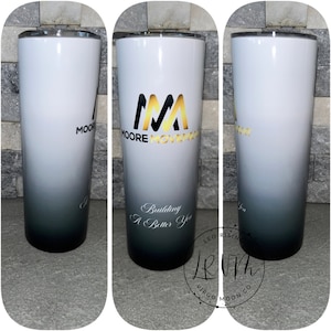 May include: A white and black ombre tumbler with a gold logo that says "Moore Movement" and the text "Building A Better You".