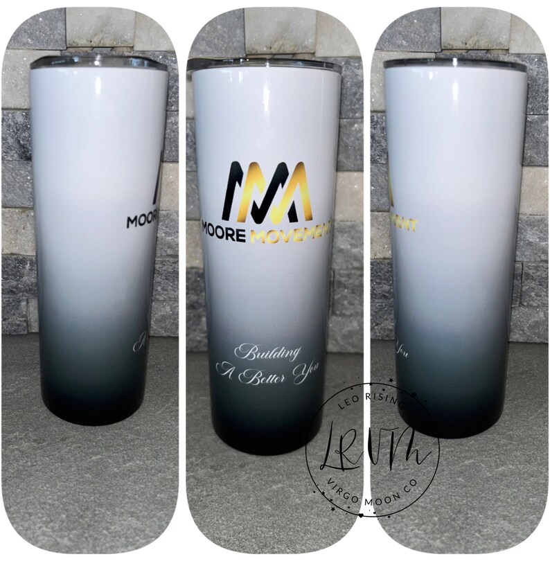 May include: A white and black ombre tumbler with a gold logo that says "Moore Movement" and the text "Building A Better You".