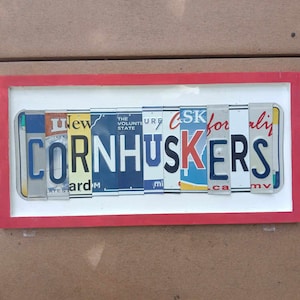 Nebraska Cornhuskers sign made with license plate letters mounted on a hand painted 20&quot;x10&quot; wood frame great gift for man cave bar wall art