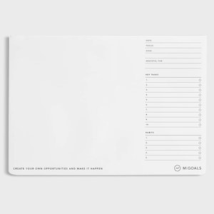 May include: White desk pad with a minimalist design. The pad has sections for date, focus, goal, key tasks, and habits. The text "CREATE YOUR OWN OPPORTUNITIES AND MAKE IT HAPPEN" is printed at the bottom. The MiGoals logo is also visible.