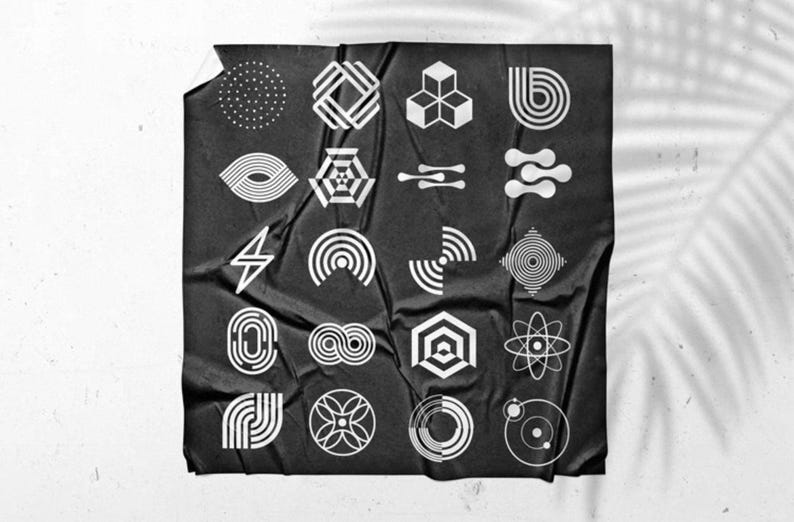 May include: A black poster with a collection of white geometric shapes. The shapes include circles, squares, and abstract designs. The poster is wrinkled and has a shadow of a leaf on the right side.