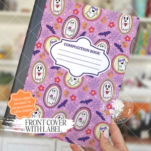 May include: A composition book with a purple cover featuring a repeating pattern of cartoon ghosts in oval frames, flowers, spiderwebs, and bats. The cover has a white label that says "COMPOSITION BOOK". The text "FRONT COVER WITH LABEL" is also visible.