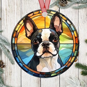 Pu&ograve; includere: Ornamento natalizio rotondo con un cane Boston Terrier in un design a vetrata. Il cane ha segni bianchi e neri con occhi marroni, su uno sfondo di tonalit&agrave; arancioni, gialle e blu. Un nastro rosso &egrave; attaccato per appenderlo.