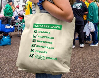 May include: A white canvas tote bag with a green check list that says "TAILGATE JAWN" and includes items like "Hoagies", "Brewskees", "Batteries", "Snowballs", "Insults", and "Philly Charm".