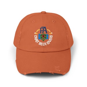 May include: A distressed orange baseball cap with an embroidered logo featuring a stylized Pennsylvania state outline with a hop and the text "PA Craft Beer Lovers".