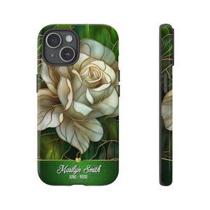 May include: A green and gold phone case with a white rose design. The case has the text "Marilyn Smith June - Rose" on the bottom.