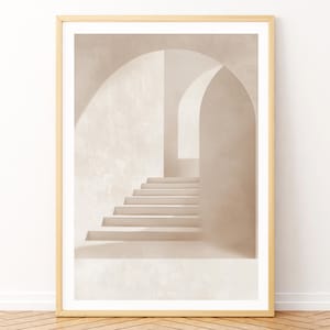 May include: A framed print of a minimalist architectural photograph. The image features a white staircase leading up to an arched doorway in a white room.