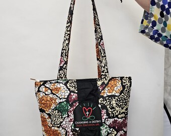 Sac fourre-tout multicolore à volants noirs avec emblème de Changer la destinée, fabriqué au Kenya pour une organisation caritative (14S)