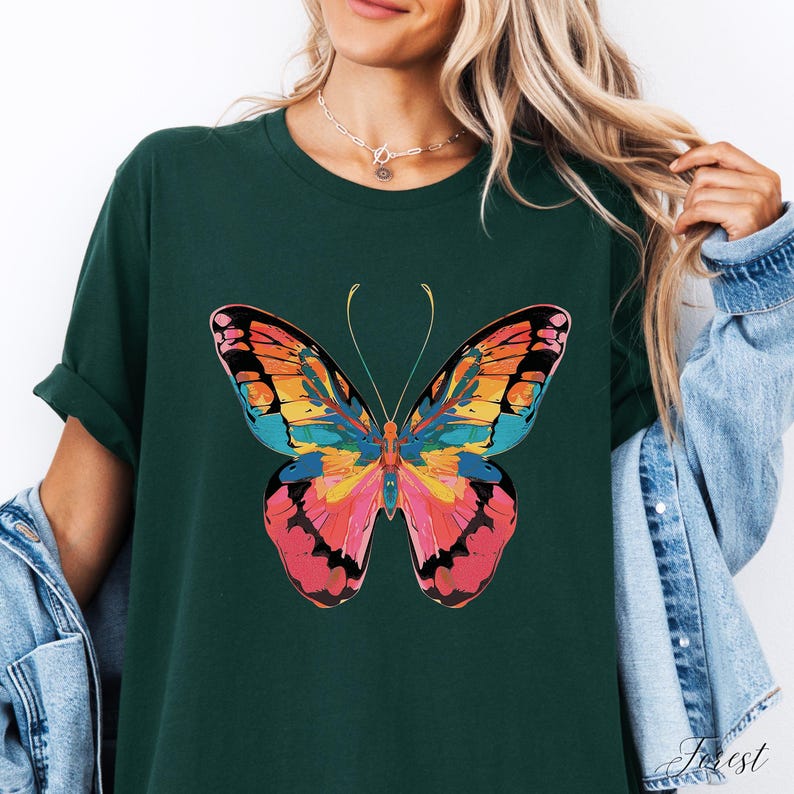 Pu&ograve; includere: T-shirt verde scuro con una grande grafica a farfalla colorata. Il design della farfalla incorpora sfumature di arancione, rosa, giallo e blu. La maglietta ha maniche arrotolate e una vestibilit&agrave; casual.