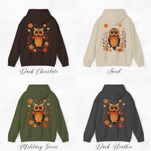 May include: Four different color hoodies with a brown owl with orange and yellow accents on the back. The owl is surrounded by flowers and leaves. The colors of the hoodies are dark chocolate, sand, military green, and dark heather.