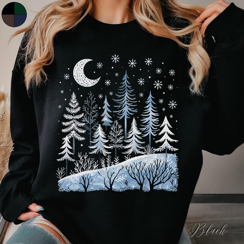 May include: Black sweatshirt with a winter scene design featuring a crescent moon, snowflakes, and a forest of blue trees.