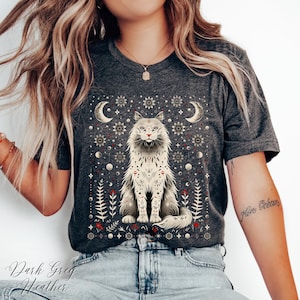 May include: Dark grey heather t-shirt with a detailed illustration of a cat and celestial designs. The cat is white with black markings, and the shirt includes the text "Dark Grey Heather".