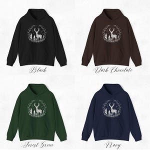 May include: Four hooded sweatshirts in black, dark chocolate, forest green, and navy blue. Each sweatshirt features a white graphic of a deer inside a wreath with the color name displayed below the sweatshirt.