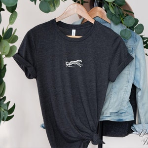 May include: Dark gray heather t-shirt with a white embroidered cheetah design.