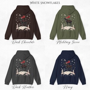 May include: Four hooded sweatshirts in dark chocolate, military green, dark heather, and navy. Each features a winter scene with a moose, snowflakes, and the text "White Snowflakes". The moose has red antlers and is standing on a snowy hill.