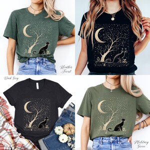 May include: Four t-shirts in dark grey, heather forest, black, and military green. Each shirt features a gold design of a crescent moon, tree, and cat. The text "Heather Forest" and "Military Green" are visible.