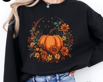 May include: Black sweatshirt with a graphic of a pumpkin surrounded by flowers and stars. The pumpkin is orange and the flowers are in shades of yellow, orange, and brown.