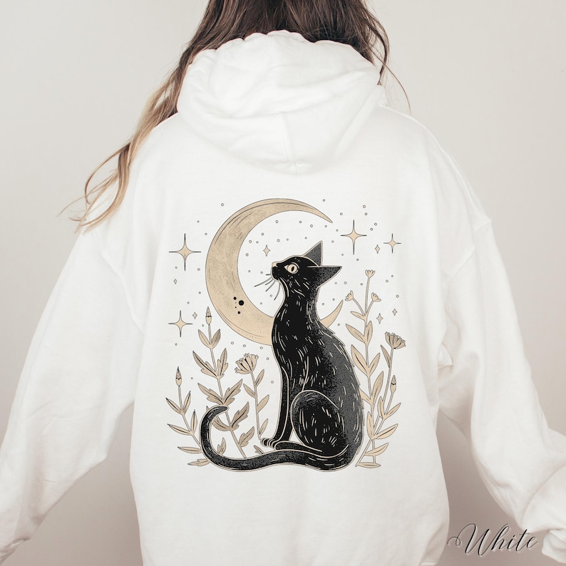 May include: White hooded sweatshirt with a black cat sitting under a crescent moon with stars and flowers. The text "White" is visible in the bottom right corner of the image.