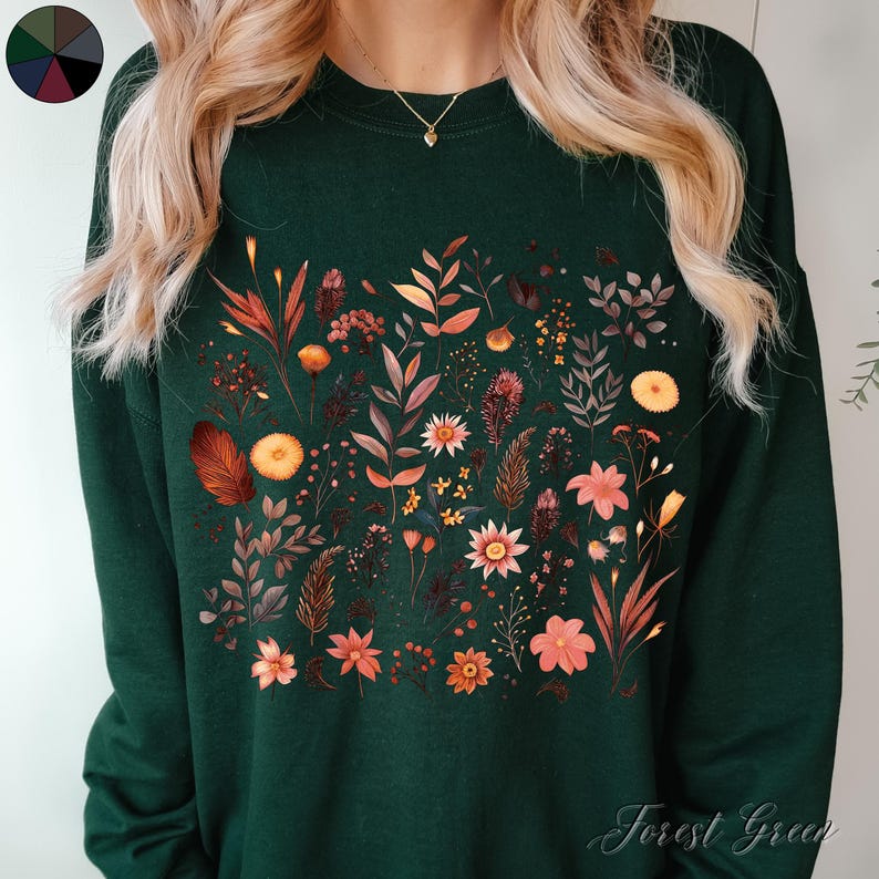 May include: A forest green sweatshirt with a floral print featuring a variety of flowers and leaves in shades of orange, yellow, and pink. The text "Forest Green" is printed on the bottom right corner of the sweatshirt.