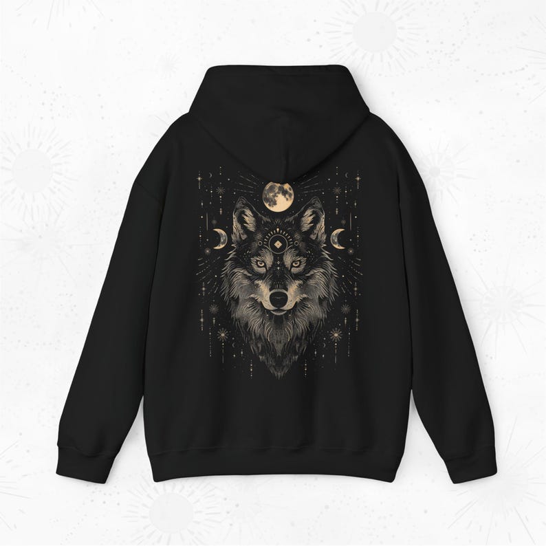 K&ouml;nnte beinhalten: Schwarzer Kapuzenpullover mit einem grafischen Aufdruck eines Wolfskopfes mit einem Mond und Sternen im Hintergrund.