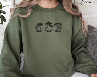 May include: A green sweatshirt with a black mushroom graphic. The sweatshirt has a crew neck and long sleeves.