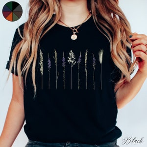May include: Black t-shirt featuring a graphic of dried flowers and grasses.