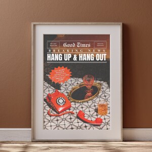 May include: A framed print with a vintage newspaper design featuring the text "Good Times Hottie Edition Breaking News Hang Up & Hang Out" with a red rotary phone and a glass of wine on a tray. The text "No More Missed Moments: Step Into The Present Now!" is in a red circle.