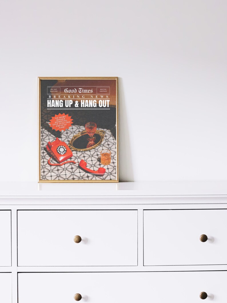 May include: A framed print with a vintage newspaper design. The headline reads "Good Times Breaking News Hang Up & Hang Out". The image features a red rotary phone, a glass of red wine, and a glass of whisky on a patterned surface.