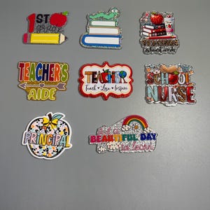 May include: Nine glitter-covered, colorful, teacher-themed, resin ornaments. The ornaments feature various designs, including a stack of books, a pencil, an apple, a rainbow, and the words "Teacher's Aide", "School Nurse", "Principal", and "It's a Beautiful Day to Learn".