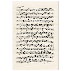 Può includere: Un foglio di musica con il titolo "Suite Pr..." e la parola "Preludio" scritta sopra le note musicali. La musica è scritta in inchiostro nero su uno sfondo color crema.