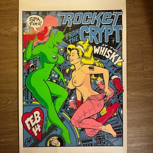 May include: A vintage concert poster for Rocket From The Crypt at The Whisky, featuring a green alien woman and a woman in pink pants, with the date February 14th.