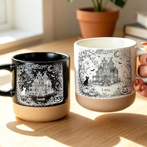 Peut inclure: Deux tasses en céramique avec une illustration détaillée en noir et blanc d'une maison hantée, de fantômes, d'un chat et de citrouilles. Une tasse est noire avec le nom Sarah, l'autre est blanche avec le nom Luna. Base en terre cuite naturelle.
