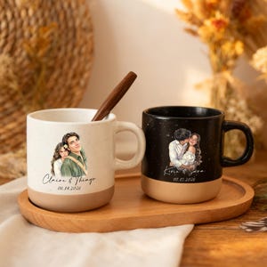 May include: Two ceramic mugs, one speckled white and one black, each featuring a custom illustration of a couple and printed names with dates. The white mug displays Claire & Thiago 06.14.2026, and the black mug shows Kevin & Sara 08.15.2026.
