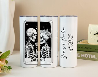 May include: White stainless steel tumbler featuring a black and white illustration of two skeletons in a tarot card design. The text "Till death" is at the bottom. The other side has the names "James & Amelia" and the date "est. 2025".