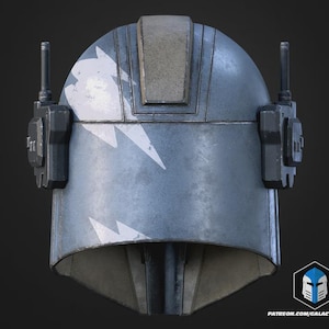 May include: A weathered, blue helmet with white lightning bolt designs. The helmet has a rectangular top section and two antenna-like structures on the sides. The design suggests a futuristic or sci-fi theme.