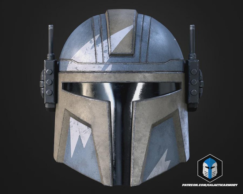May include: A Mandalorian helmet with a weathered, battle-worn appearance. The helmet features a blue and tan color scheme with white chevron markings. It has a visor and two antenna-like structures on the sides. The bottom right corner has a logo and website address.