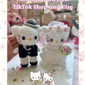 May include: Crocheted Hello Kitty bride and groom figures. The groom wears a black tuxedo and gray hat, while the bride has a veil and holds a pink bouquet. The image includes the text "Available on our TikTok Shop and Etsy."