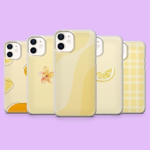 May include: Five yellow phone cases with different designs, including a lemon slice, a flower, and abstract shapes. The cases are arranged in a row against a purple background.