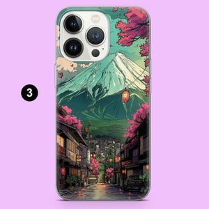 May include: A phone case featuring a Japanese landscape illustration. The design includes a snow-capped mountain, a street lined with traditional buildings, and cherry blossom trees. The case has a clear border and a light purple background.