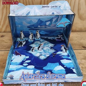Puede incluir: Un diorama de papel de la Antártida, con pingüinos, orcas y focas sobre témpanos de hielo. La escena está ambientada en una caja con una combinación de colores azul y blanco, con el texto "Antarctica diorama" y "Super easy! Print, cut, fold, glue".